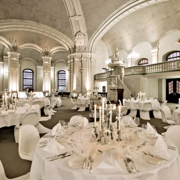 Large hall with laid tables and chairs in white