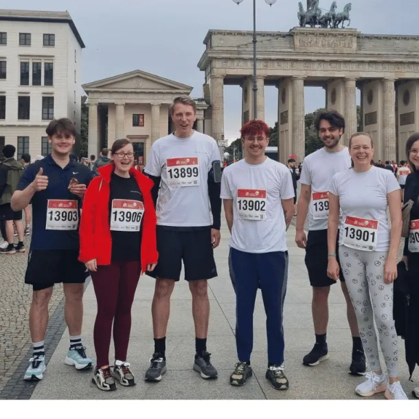 echs Läufer:innen aus dem Team der Besonderen Orte vor dem Brandenburger Tor